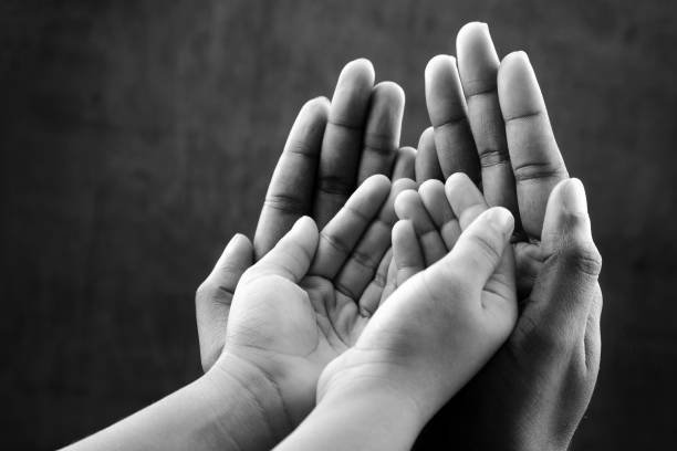 monochrome image of hands of a kid on an elder's